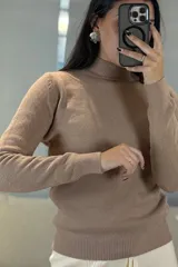Buzo de tejido de punto color rosa, con cuello alto y puños acanalados.