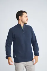 Sweater de tejido de punto acanalado en color negro, con cuello alto y cierre frontal parcial. Cuenta con mangas largas y un pequeño logo bordado en el ruedo.