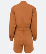 Mono corto color ladrillo, de sarga de algodón, con cuello mao, mangas abullonadas largas, cierre frontal con botones dorados, bolsillos laterales y cintura marcada.