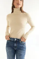 Polera de algodón color beige con cuello alto y mangas largas.
