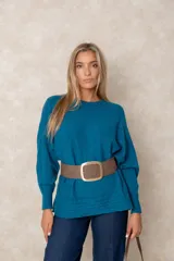 Buzo de punto color azul petróleo, con cuello redondo, mangas largas con puños ajustados y detalles de textura trenzada en la parte superior y el ruedo.