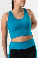 Top deportivo de color azul francia, con escote redondo y breteles anchos. Presenta un diseño de faja ancha en la parte inferior para mayor sujeción y ajuste al cuerpo.