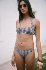 Conjunto de bikini con estampado de cuadrillé azul marino y blanco, compuesto por un corpiño halter con tiras para atar en el cuello y la espalda, y una bombacha semivedetina.