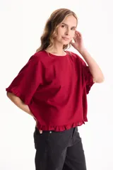 Blusa de lino color rojo, de manga corta y corte holgado, con detalles de volados en los puños y el ruedo.