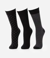 Set de tres pares de medias de caña alta, confeccionadas en algodón. Un par es liso color negro, otro par es negro con lunares blancos y el tercero es negro con rayas horizontales blancas.