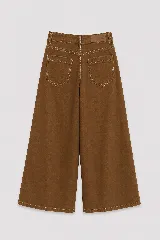 Pantalón de jean color naranja con tiro medio, diseño de pierna ancha y cinco bolsillos. Presenta costuras con pespuntes a contratono.