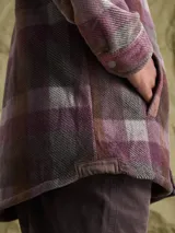 Sobrecamisa de tejido polar con estampado abstracto en tonos rojizos y azul marino. Presenta cuello clásico, cierre frontal con botones a presión, dos bolsillos frontales con solapa en el pecho y un parche decorativo.