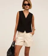 Short de sarga color beige, de cintura alta, tiro regular, con bolsillos frontales y traseros, cierre de botón y cremallera, y pespuntes en contraste.