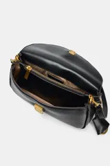 Bolso bandolera de formato alargado en color negro, con solapa frontal y cierre metálico. Incluye una correa ajustable de tejido en color crudo y herrajes dorados.