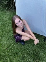 Vestido corto negro con diseño cut-out en la cintura, estilo strapless y ruedo decorado con flecos largos.