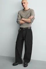 Pantalón cargo de corte relajado confeccionado en tejido de algodón con elasticidad. Presenta bolsillos laterales tipo cargo con solapa en las perneras, bolsillos frontales y bolsillos traseros de doble vivo. Cierre frontal con cremallera y botón.