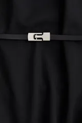 Vestido corto negro, de corte entallado, con cuello redondo y mangas cortas raglán. Incluye un cinturón fino con hebilla metálica decorativa.