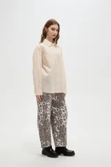 Camisa de algodón con estampado de rayas verticales finas, cuello camisero, cierre frontal con botones y bolsillos frontales tipo parche.