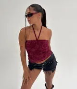 Top halter color bordó con textura de encaje floral y escote recto.