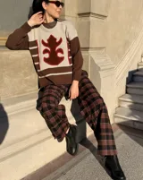 Sweater de punto con diseño color block en tonos marrón y beige, con detalle central de aplique de cuero con contorno bordado a mano.