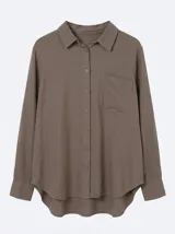 Camisa de manga larga color negro, de corte holgado, cuello camisero, cierre frontal con botones y un bolsillo aplicado en el pecho. Confeccionada en mezcla de lino y viscosa.