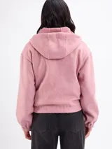 Campera de paño color beige con capucha, cierre frontal completo y mangas largas con puños elásticos. Presenta un diseño corto con ruedo elástico.