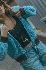 Campera tejida calada de color negro con detalles en rojo en el cuello alto, los puños, la cintura y las costuras de las mangas raglán. Cuenta con cierre frontal completo.