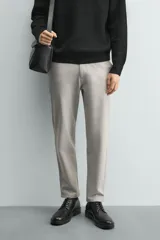 Pantalón chino de corte slim fit, confeccionado en tejido elástico. Presenta bolsillos frontales, bolsillos traseros de vivo con botón y cierre frontal con cremallera y botón.