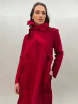 Tapado rojo de lana merino afieltrada, corte recto con lazos para ajustar en la cintura y cuello alto con posibilidad de cruzar los lazos alrededor. Tiene bolsillos laterales.