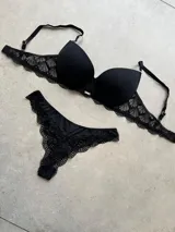 Conjunto de lencería compuesto por un corpiño taza soft de microfibra con detalles de puntilla y una bombacha tipo less a juego con encaje.