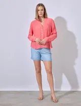 Blusa color salmón de gasa marca Zac & Rachel, con cuello a la base, escote en V, botones y detalle plisado en la parte delantera. Mangas largas regulables con presilla y botón.