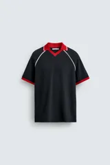 Polo de corte relajado confeccionado en tejido de algodón con estructura abierta. Presenta cuello polo con abertura frontal en V, mangas cortas tipo ranglán y acabados en rib a contraste en color rojo y blanco.