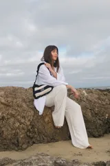 Cartera tejida a crochet con hilo 100% de algodón. Diseño a rayas horizontales en tonos de rojo y rosa, con volados en el borde y en el asa.