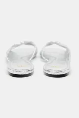 Sandalia plana plateada con tiras cruzadas y detalle de nudo en la parte superior.