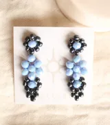 Par de caravanas colgantes con cristales celestes y negros.