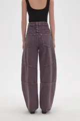 Pantalon de jean estilo barrel con tiro alto, diseño de paneles reforzados en las piernas y costuras visibles con remaches metálicos.