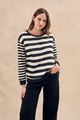 Sweater de punto a rayas horizontales anchas en color negro y crudo, de corte oversize, mangas largas y cuello redondo.