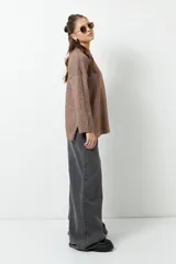 Polera marrón de tejido de punto con cuello alto y corte oversized.