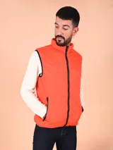 Chaleco puffer color naranja con cierre frontal y bolsillos laterales con cierre.