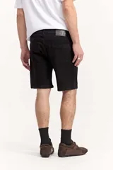 Bermuda de jean negra de corte regular y largo por encima de la rodilla, con diseño clásico de cinco bolsillos y trabillas para cinturón.