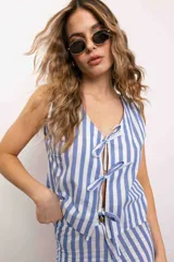 Blusa celeste con rayas verticales blancas, escote en V y cierre frontal con lazos.