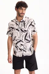 Camisa de viscosa de manga corta con corte clásico, fondo blanco y estampado abstracto en color negro.