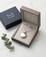 Collar con dije tipo relicario circular de acero inoxidable, diseñado para insertar fotografías en su interior.