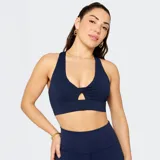 Bra deportivo de impacto medio color azul marino, con diseño de nudo frontal y abertura ventilada. Presenta tirantes cruzados en la espalda y banda elástica inferior para mayor sujeción.