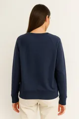 Sudadera negra de cuello redondo, manga larga tipo raglán y corte holgado.