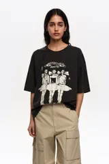 Remera de corte recto y diseño oversize, confeccionada en algodón orgánico. Presenta escote redondo, mangas cortas y estampa frontal en blanco y negro con la ilustración de bailarinas y la inscripción "Bimba y Lola Dancers".