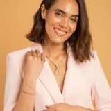 Pulsera de cadena fina en oro 18k con dijes de circonias engarzadas distribuidos a lo largo de la misma.