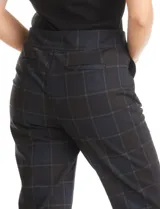 Pantalón sastrero de tiro alto y pierna recta, confeccionado en tejido con estampado cuadrille en tonos oscuros. Presenta pretina con botones decorativos y bolsillos laterales inclinados.
