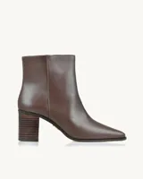 Bota corta de cuero color marrón, con taco cuadrado y punta fina.