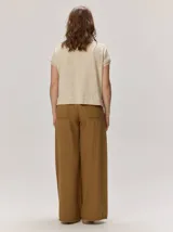 Remera negra de punto fino, con mangas cortas, cuello redondo y corte relajado. Cuenta con costuras verticales decorativas en el frente.