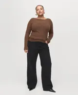 Jeans negros de tiro medio a bajo, corte recto y holgado, con diseño clásico de cinco bolsillos y cierre frontal con botón y cremallera.