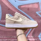 Championes Nike Air Force 1 de corte bajo, color blanco con detalles en textura de piel de serpiente en tono bronce en el swoosh lateral y en el talón.