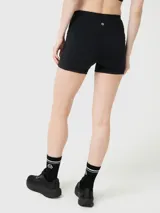 Calza corta deportiva de tiro alto, color negro, con ajuste al cuerpo y bolsillos laterales. Confeccionada en tejido suave con tecnología Aloe Vera y banda de silicona para mayor sujeción.