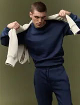 Sweater básico de cuello redondo y manga larga, confeccionado en tejido circular con puños y cuello en tejido canalé.