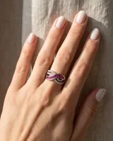 Anillo de plata 925 con diseño entrelazado decorado con rubíes baguette centrales y circonias cúbicas engastadas en pavé.